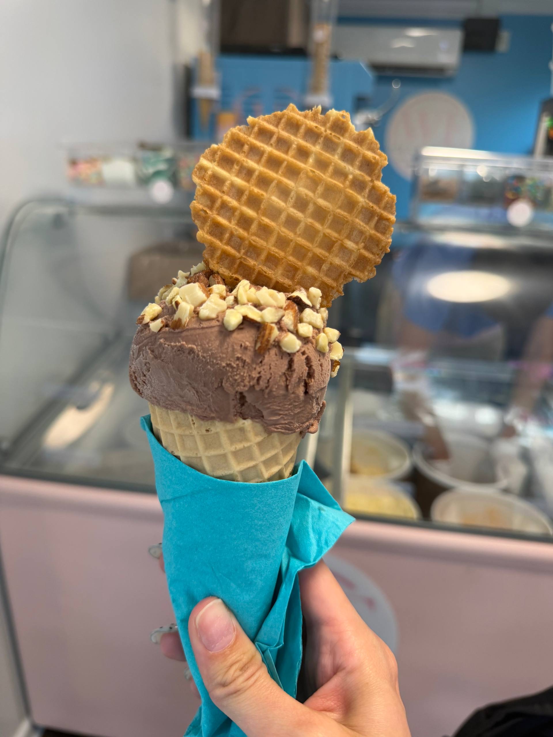 Cono de chocolate con almendras frente al mostrador rosado de WE